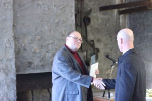 A photo of Greg Gilchrist accepting the award on behalf of John Gilchrist
